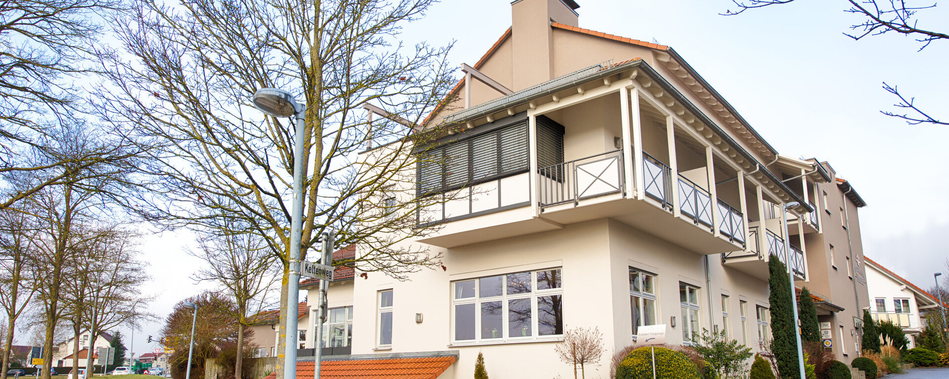 Das elegante Landhaus Feckl bei Sindelfingen mit Bäumen im Vordergrund.