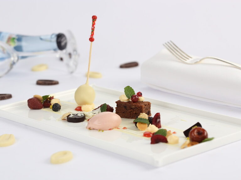 Ein weißer Teller mit raffinierten Desserts im Sterne-Restaurant Landhaus Feckl bei Stuttgart.
