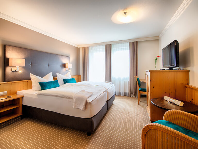 Das stilvolle Komfortzimmer mit einem großzügigen Bett und Balkonzugang im Landhaus Feckl.