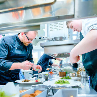 Das Team von Köchen in der Küche des Sternerestaurant Landhaus Feckl bei Stuttgart, konzentriert sich auf die Zubereitung der Speisen.