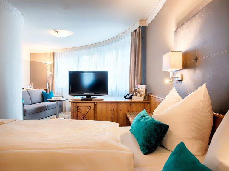Ein einladendes Bett mit dekorativen Kissen im Komfortzimmer für Businessreisendes- Böblingen.