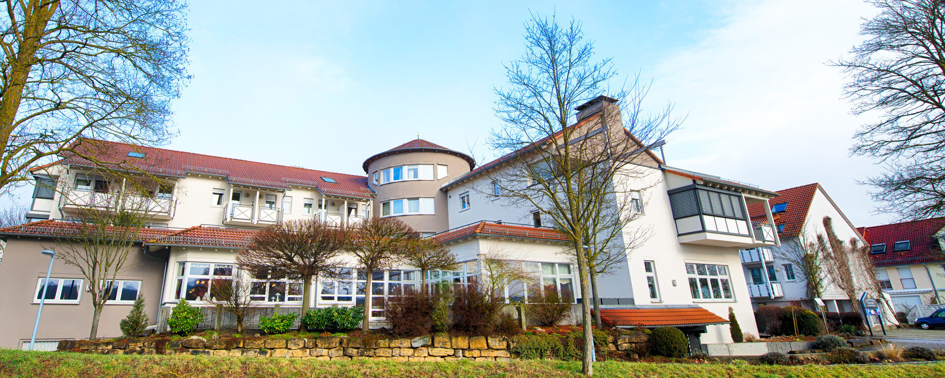 Das elegante Landhaus umgeben von gepflegter Grünlandschaft im Frühling.