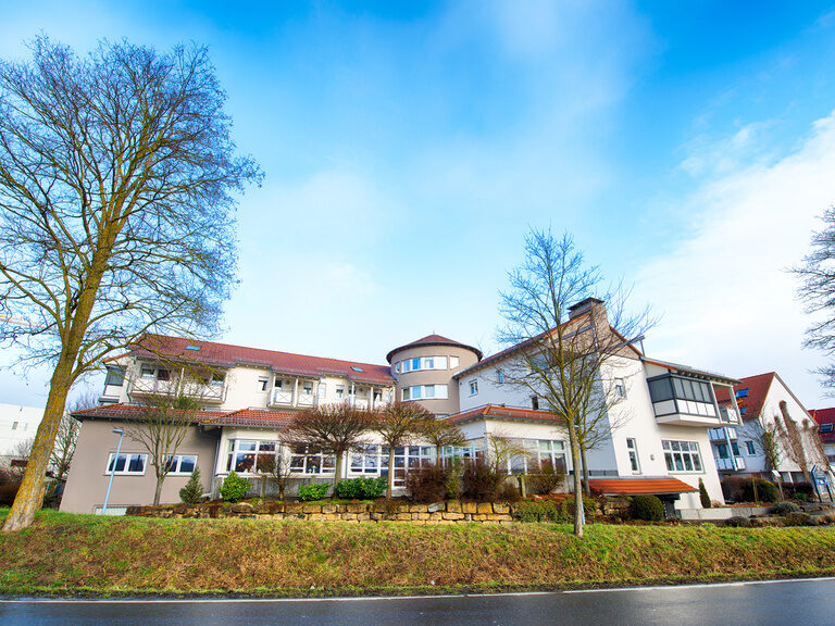 Das elegante Landhaus umgeben von gepflegter Grünlandschaft im Frühling.