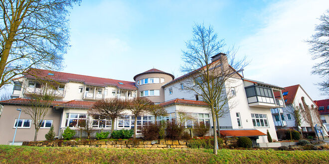Das elegante Landhaus umgeben von gepflegter Grünlandschaft im Frühling.