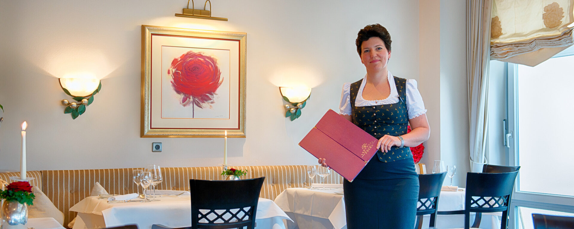 Stilvoll gekleidetes Servicepersonal mit der Menükarte im Hotelrestaurant Feckl.