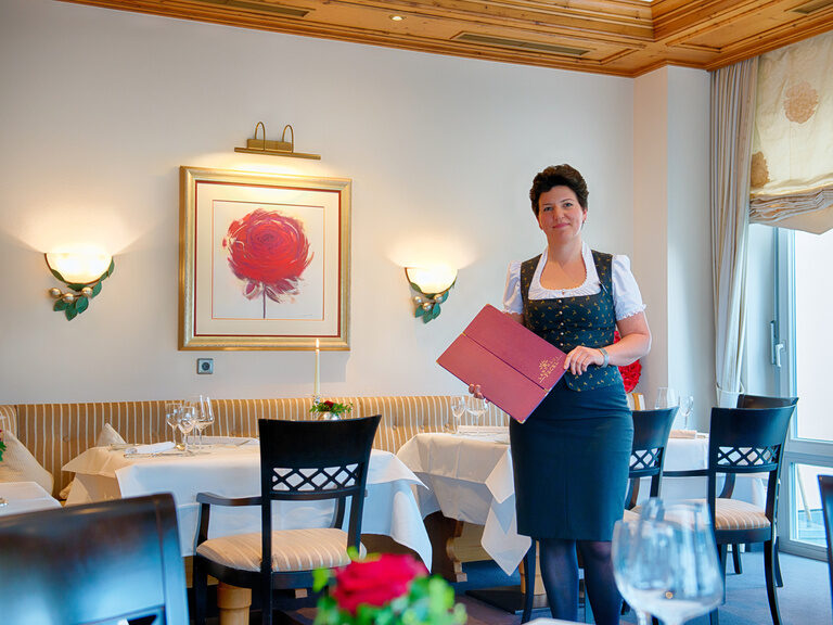 Stilvoll gekleidetes Servicepersonal mit der Menükarte im Hotelrestaurant Feckl.
