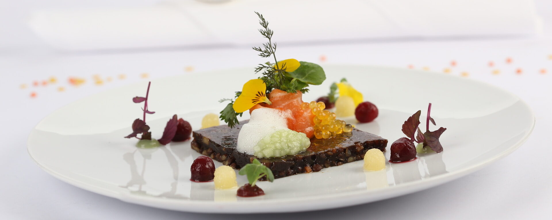 Ein kunstvoll angerichteter Teller mit Gourmet-Speisen im Restaurant von Landhaus Feckl.
