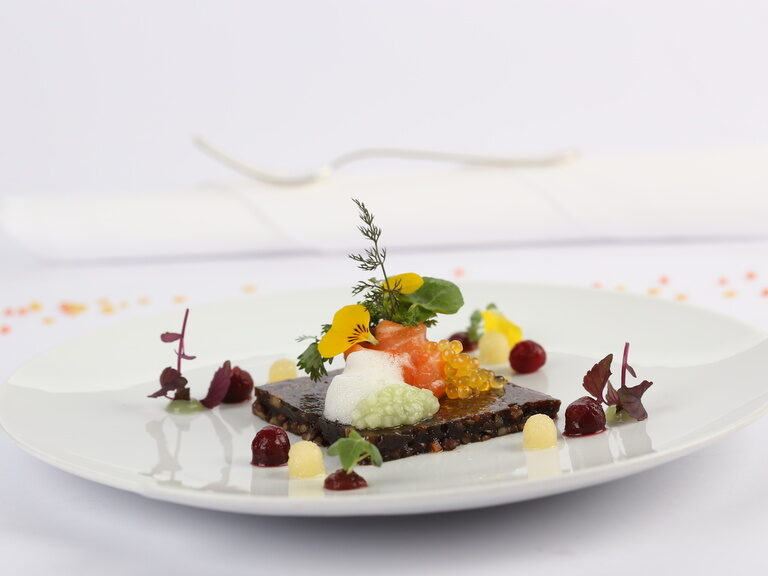 Ein kunstvoll angerichteter Teller mit Gourmet-Speisen im Restaurant von Landhaus Feckl.