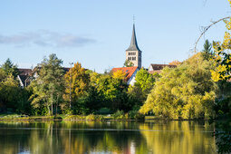 Eine harmonische Landschaft bei Sindelfingen mit spiegelndem Wasserlauf und grünen Uferbäumen.