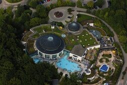 Eine atemberaubende Luftaufnahme der Mineral Therme mit weitläufigen Schwimmbecken und üppiger Landschaftsgestaltung.